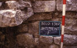 Bâtiment F. Sondage F1 sous escalier NE. Mur est fondation plus large à gauche sous l'escalier.